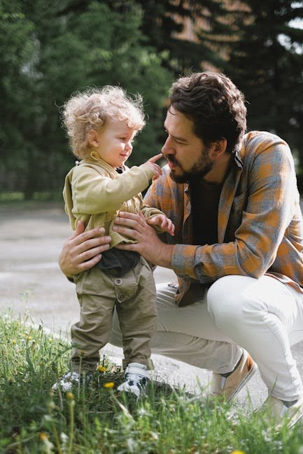 A father and his young son share a playful moment outdoors, emphasizing family and bonding.